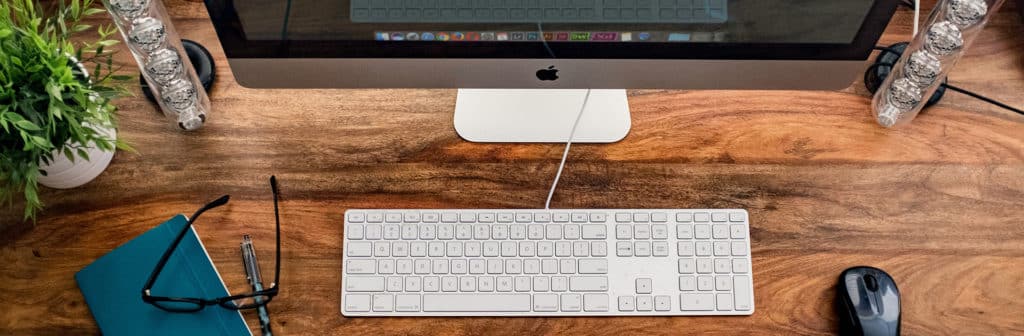 i-mac posé sur une bureau avec clavier et souris